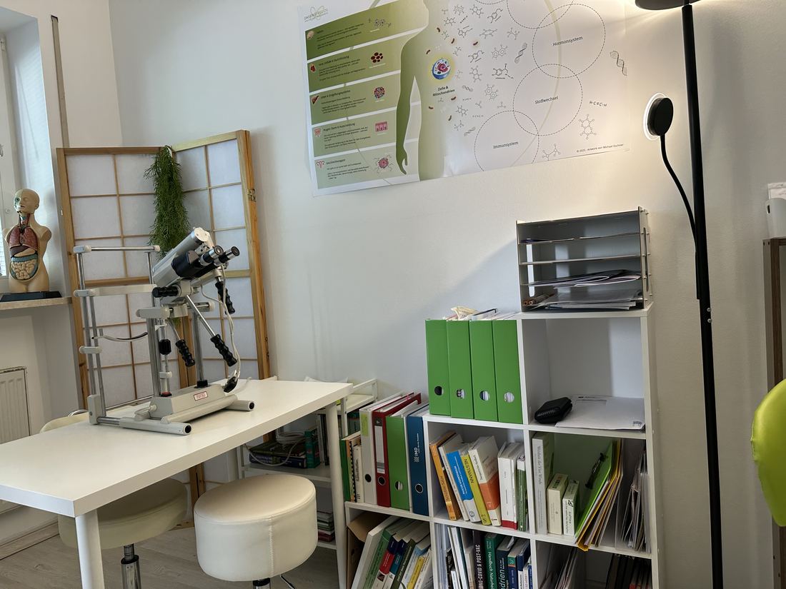 Behandlungsraum mit Augendiagnose-Gerät und Fachbibliothek
